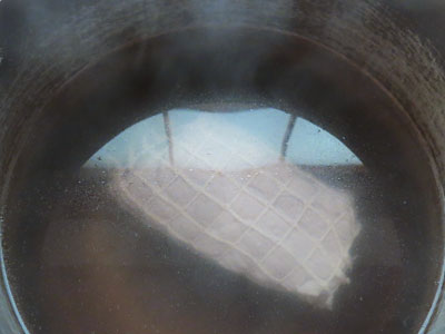 沸騰した湯で湯通しするチャーシュー肉