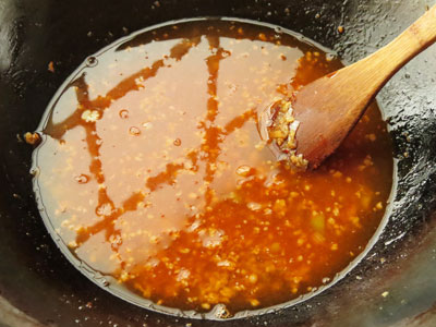 ひき肉を炒めているフライパンに、水で溶いた鶏がらスープの素を入れる