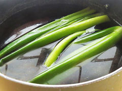 沸騰した湯に牛モツを入れる