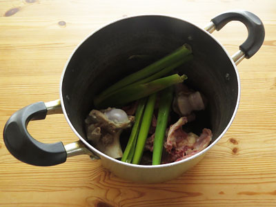 鍋に豚骨と鶏がら、臭み消しの材料を入れる