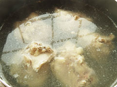 沸騰した湯で骨付き鶏肉を下茹でする
