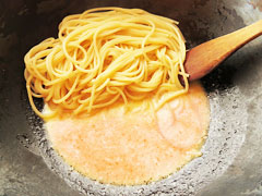茹で上がったスパゲティをクリームソースの入ったフライパンに入れる。