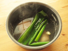 臭み消し用のネギの青い所と生姜の薄切り、にんにくを入れ、沸騰した湯を注ぐ