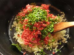 炒めた玉ねぎが入った鍋に挽き肉と赤ワイン、ハーブを入れる