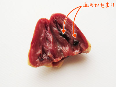 縦に切れ目を入れて開いた鳥ハツの血の塊を取り除く図