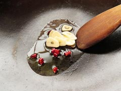 オリーブオイルをひいたフライパンでにんにくと鷹の爪を炒める