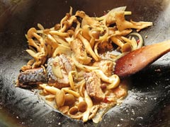 サバ缶を炒めながら醤油を入れて味付けする