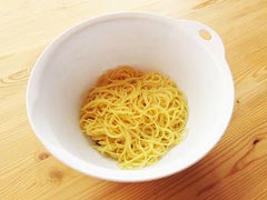 茹で上がったパスタ麺をボウルに入れる