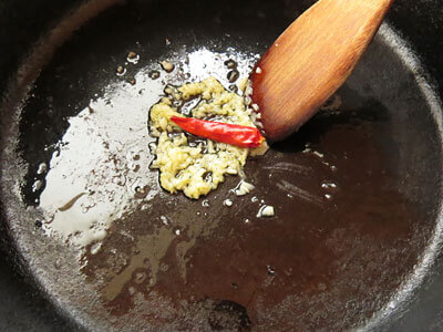 オリーブオイルをひいた鍋でにんにくと鷹の爪を炒める