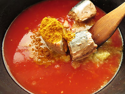 野菜を炒めた鍋にトマトジュースと酒、さば水煮缶、カレー粉、ヨーグルトを入れる