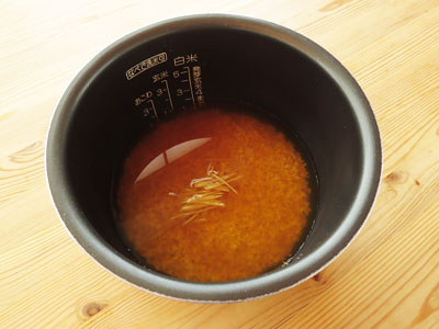 米を入れた炊飯器の釜に、炊き込みご飯のだし汁を注ぐ