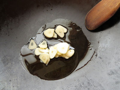 フライパンにオリーブオイルとスライスしたにんにくを入れる
