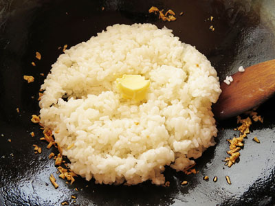 フライパンにごはんとバターを入れる