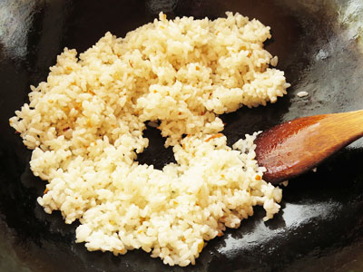 ごはんを炒めているフライパンに鍋肌から醤油を入れる