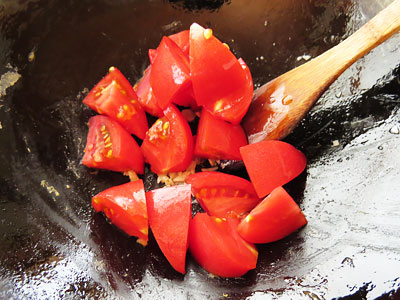 フライパンにトマトを入れる