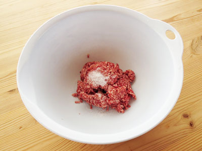 合い挽き肉の入ったボウルに塩を入れる