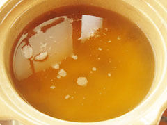 100均の一人用土鍋にだし汁と醤油、酒、おろししょうがを入れる