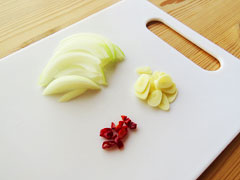薄切りにした玉ねぎとにんにく、小口切りにした鷹の爪