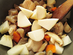 野菜を炒めている鍋に里芋を入れる