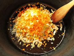 にんにくとベーコンを炒めている鍋に、みじん切りにした野菜を入れる。