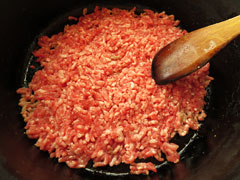 ひき肉を鍋底に押し付けるように、木べらで平らにならす。