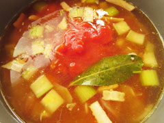 野菜を煮込んでいる鍋に缶のトマト煮(ダイスカット)を入れる。