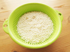 ざるにあげて水切りしている米。
