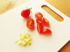 1/4等分に切り分けたミニトマトと、にんにくのみじん切り。