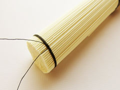 素麺の束を糸で縛る。