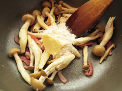 ベーコンとしめじを炒めているフライパンに、バターと小麦粉(薄力粉)を入れる。