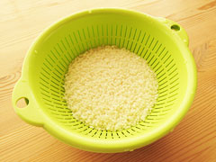 洗った生米を、ざるに上げて水を切る。