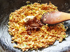 ひき肉を炒めているフライパンに、味噌と醤油、砂糖、酢を入れる。