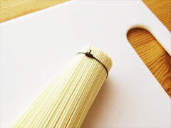 素麺の束を糸で縛る。