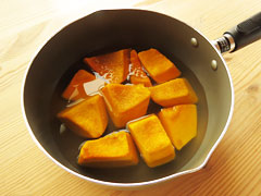 鍋に切り分けたかぼちゃを、皮面を下に重ならないように並べ、調味液を入れる。