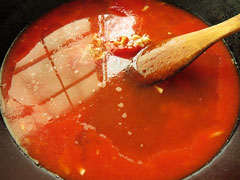 トマトジュースと水を加えてひと煮立ちさせる。