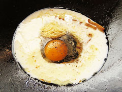 ベーコンを炒めたフライパンに牛乳と卵、パルメザンチーズを入れる。