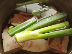 鍋に豚足とネギの青いところ、にんにく、生姜、酒、水を入れる。