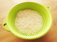 洗った米をざるに入れて水を切る。