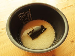 米とゆで汁、酒、塩、昆布を入れた炊飯器の内釜。