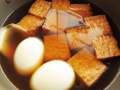 厚揚げを焼いている鍋にゆで卵と生姜、だし汁を入れて煮る。