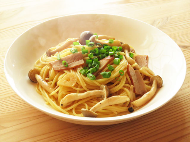 白いお皿に盛りつけられたきのことベーコンのパスタ