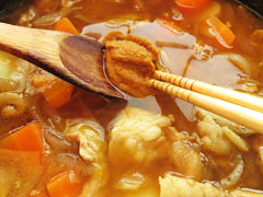 スープでのばしたカレールーを、野菜と豚肉を煮込んでいる鍋に溶き入れる。