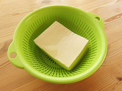 豆腐をざるに入れ、水気を切る。