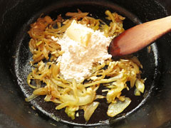 きつね色になるまで炒めた玉ねぎに、小麦粉を加える。