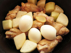手羽元と大根を煮込んでいる鍋にゆで卵と生姜を入れる。
