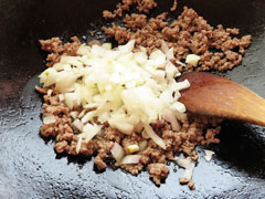 合い挽き肉を炒めているフライパンに玉ねぎを入れる。