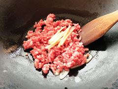にんにくを炒めているフライパンに、合い挽き肉を入れる。