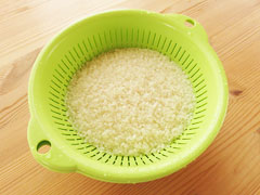 水で洗った米をざるに上げて水を切る。