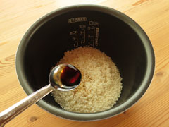 米の入った炊飯器の内釜に調味料を加える。