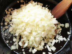 にんにくとベーコンを炒めている鍋に、玉ねぎのみじん切りとバターを入れる。